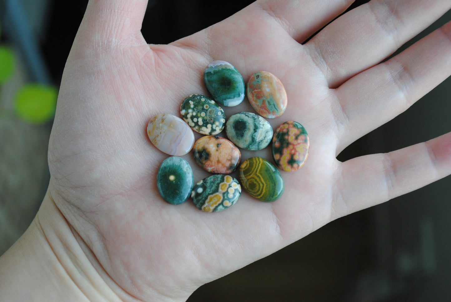 Ocean jasper stones colorful ovals on the palm of a hand
