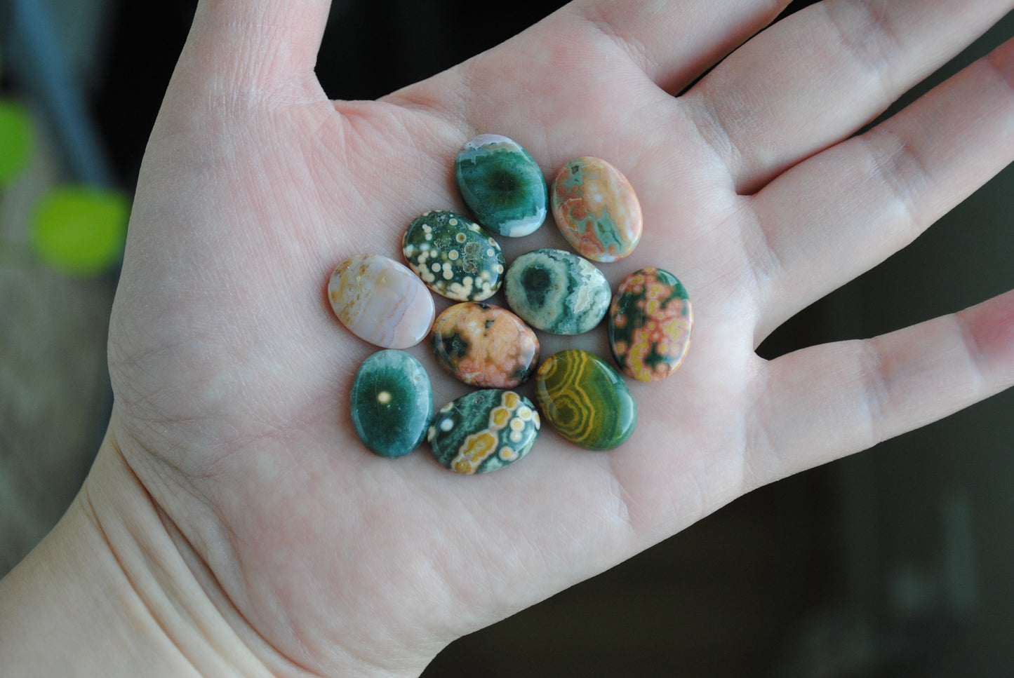 Ocean jasper stones colorful ovals on the palm of a hand