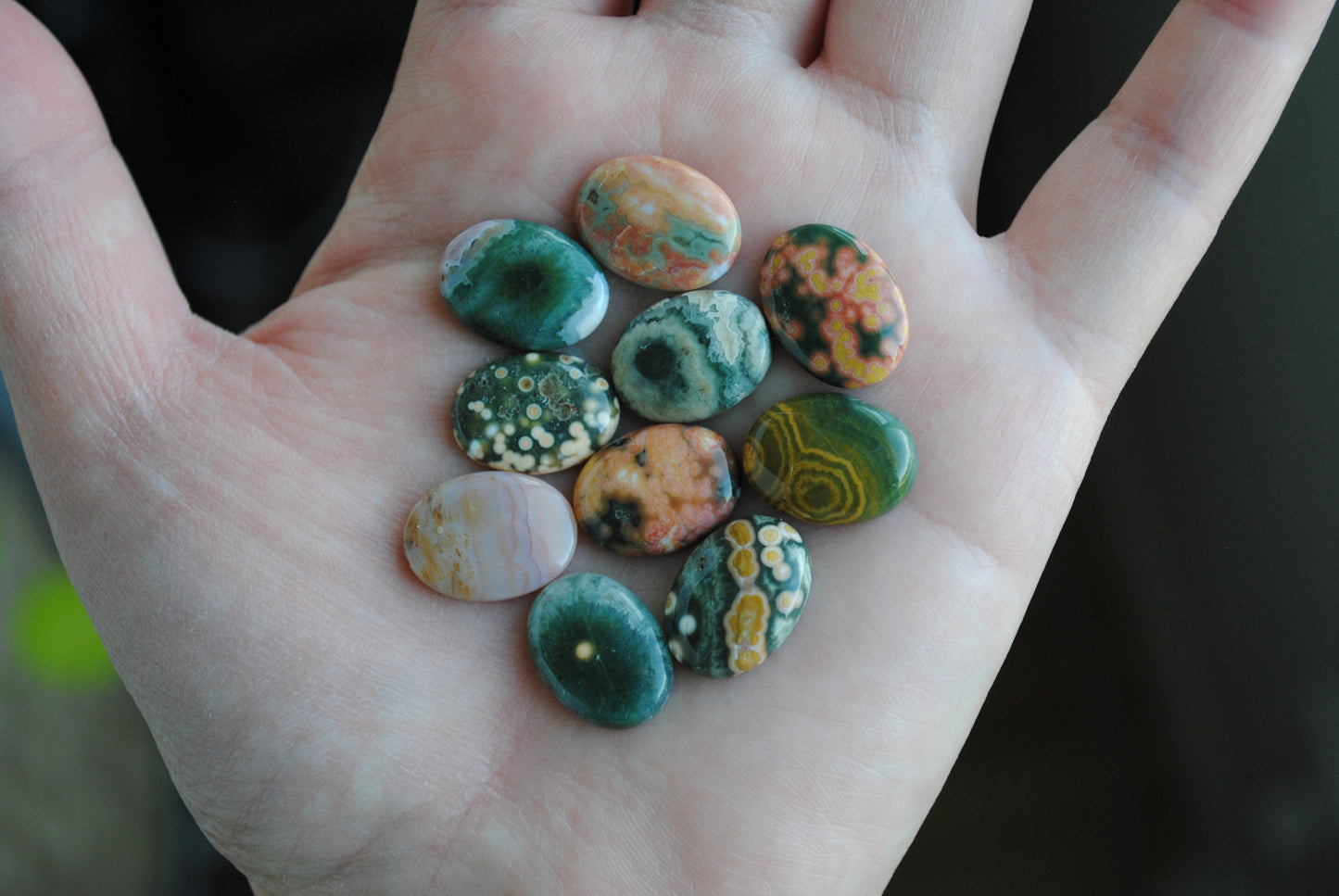 Ocean jasper stones colorful ovals on the palm of a hand