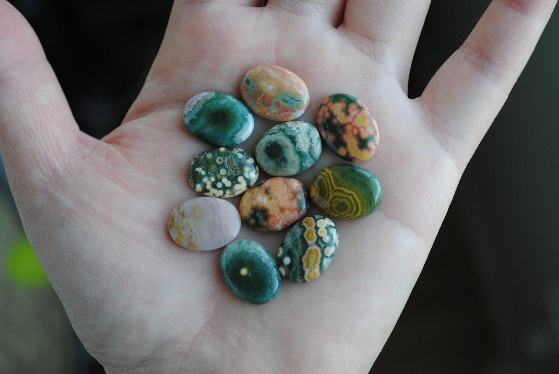 Ocean jasper stones colorful ovals on the palm of a hand