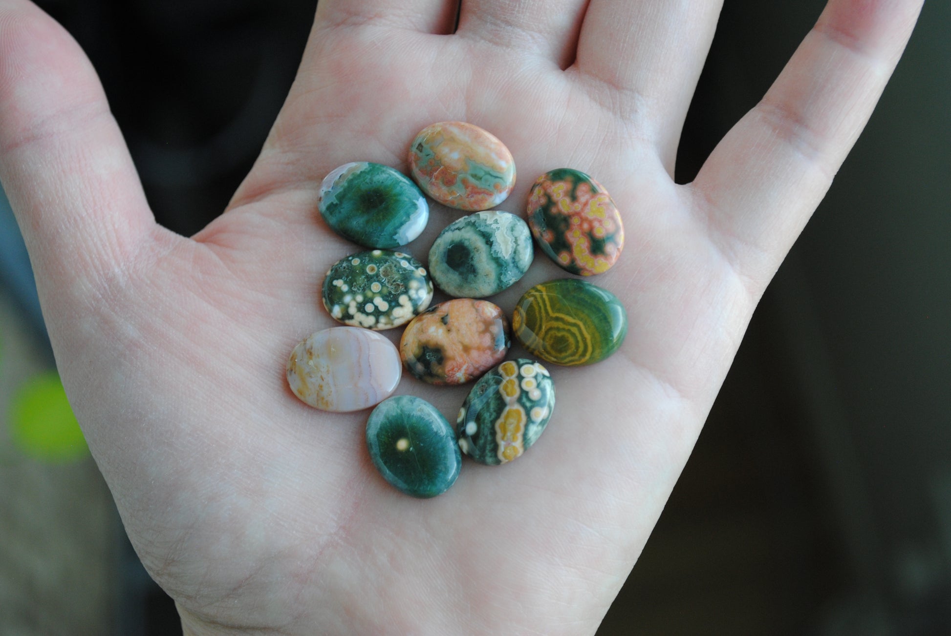 Ocean jasper stones colorful ovals on the palm of a hand