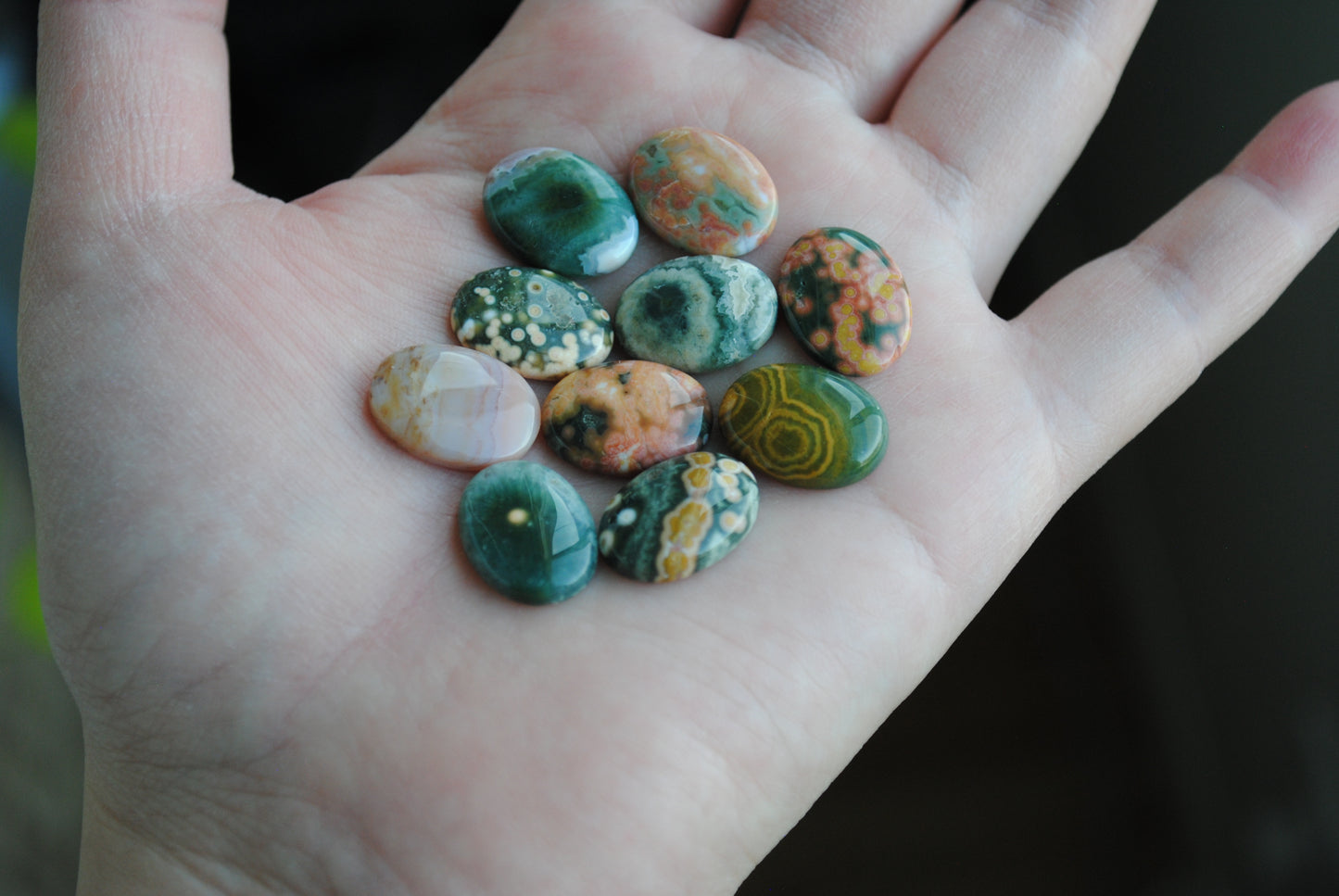 Ocean jasper stones colorful ovals on the palm of a hand