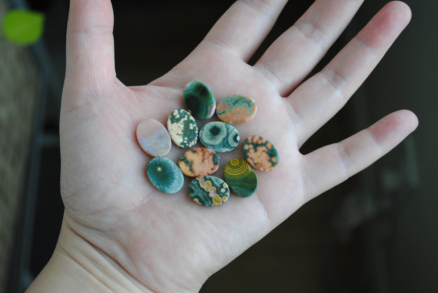 Ocean jasper stones colorful ovals on the palm of a hand