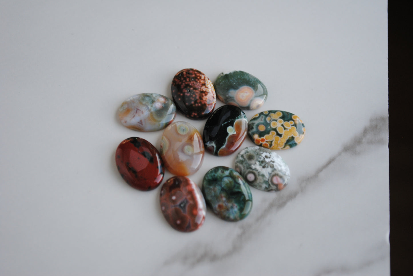 Collection of colorful marbled stones on a marble surface