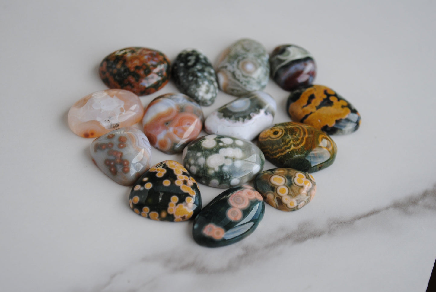 Collection of multicolored marbled stones on a marble surface