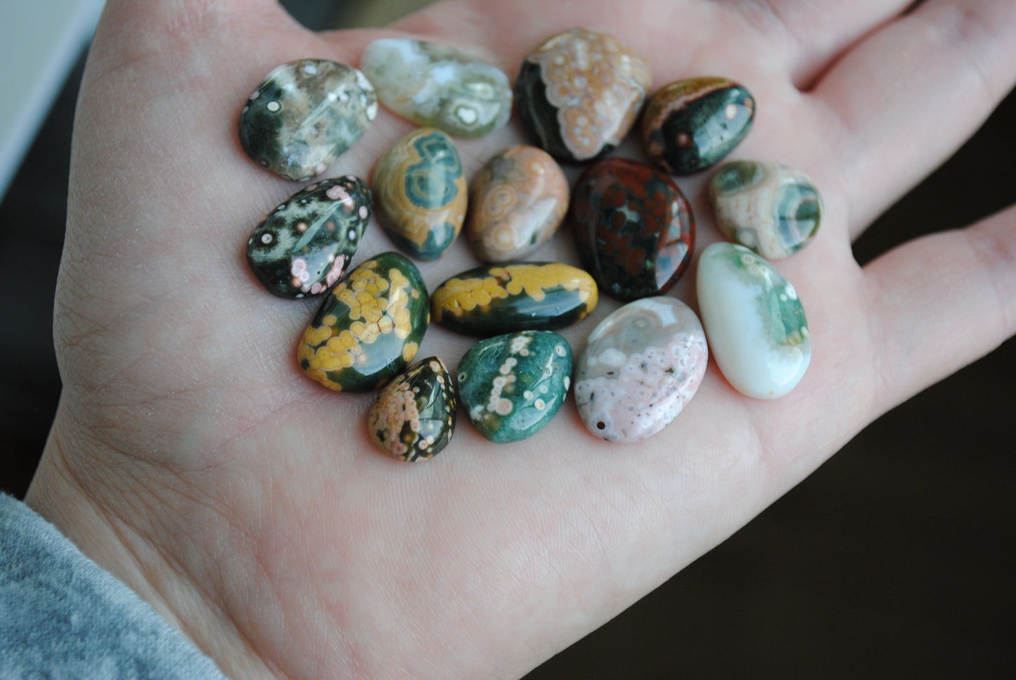 Hand holding a collection of multicolored stones