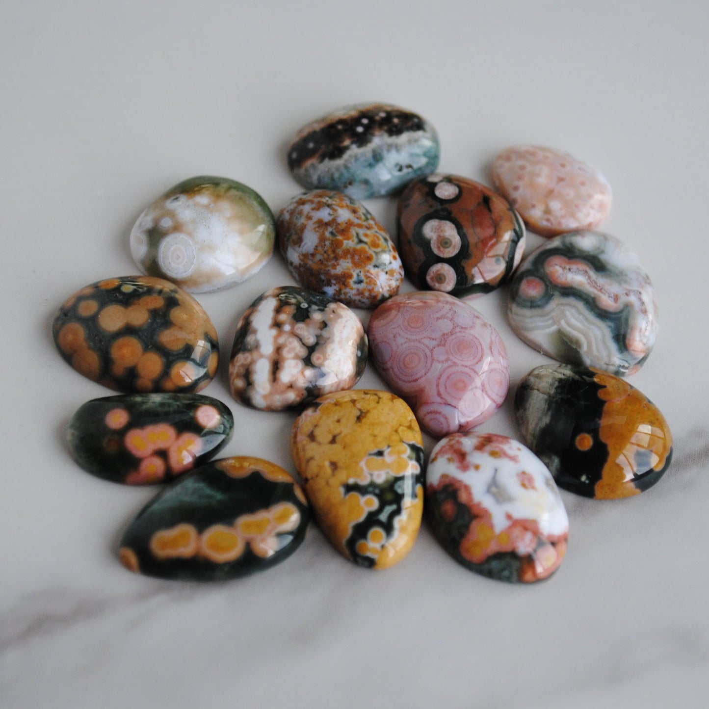 Collection of multicolored marbled stones on a marble surface