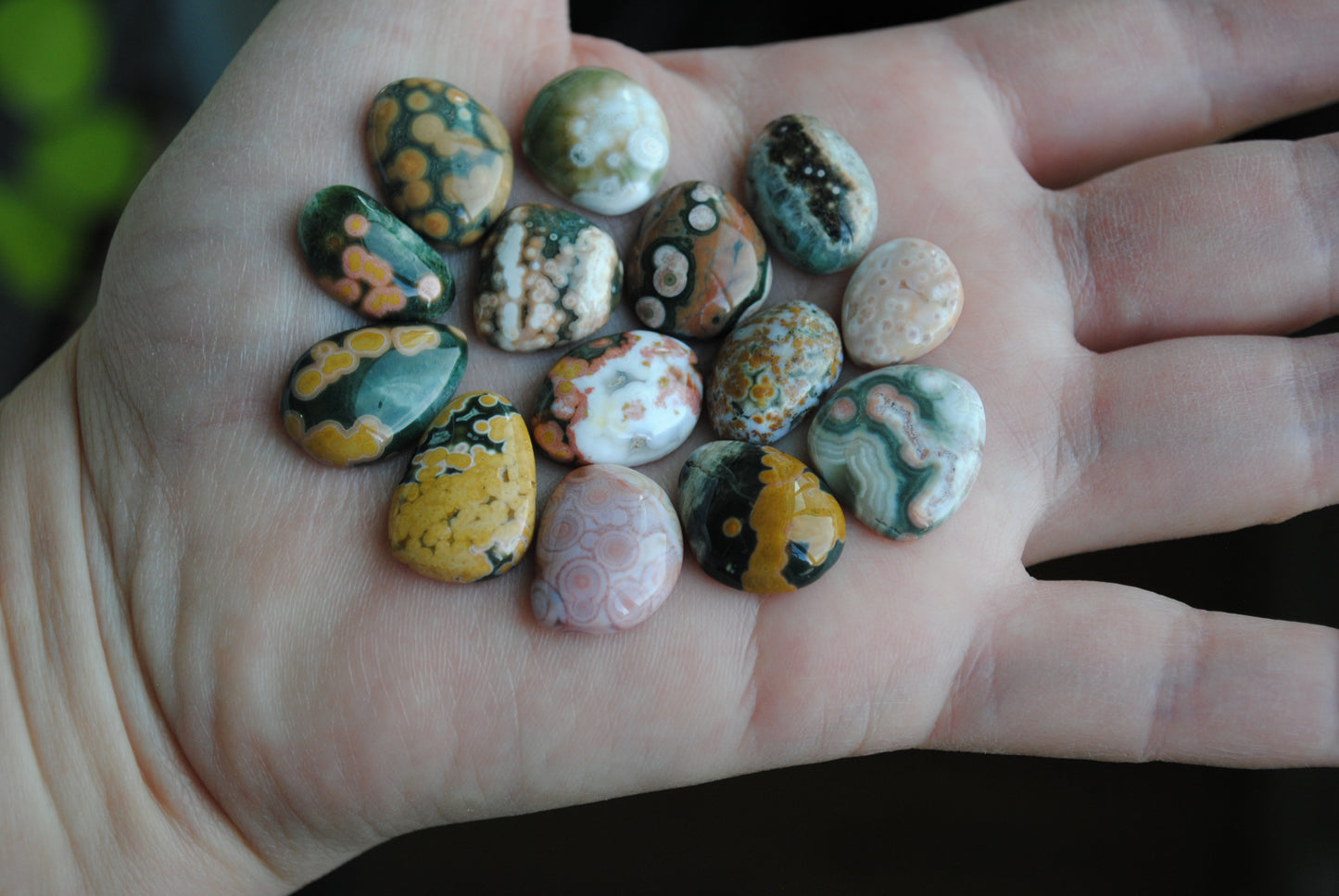 Hand holding a collection of small, multicolored stones.