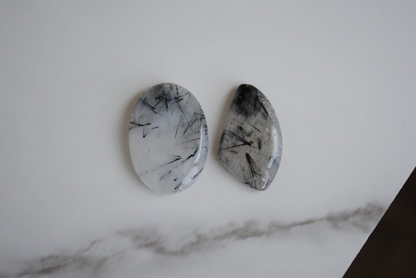 Tourmalinated quartz cabochons on a light background