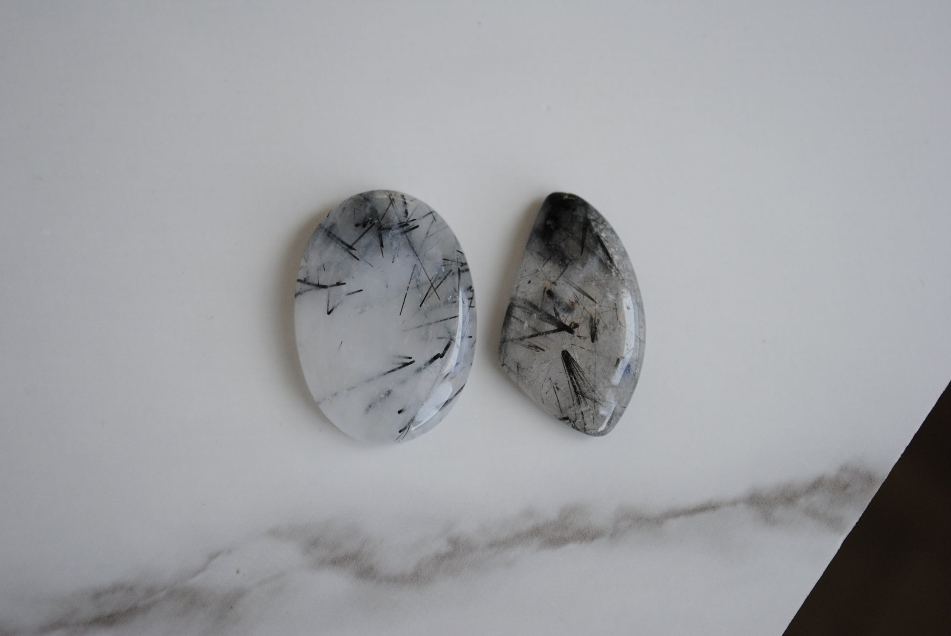 Tourmalinated quartz cabochons on a light background