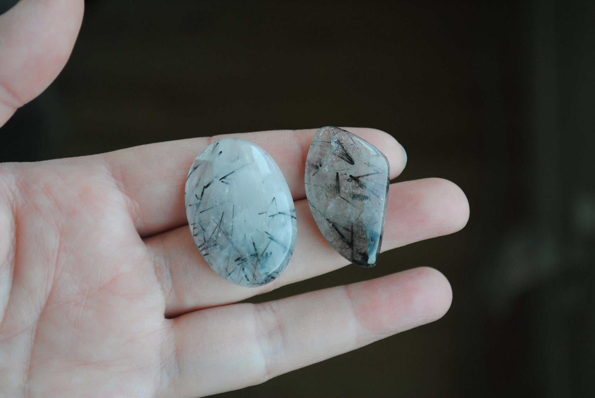 Tourmalinated quartz cabochons on fingers