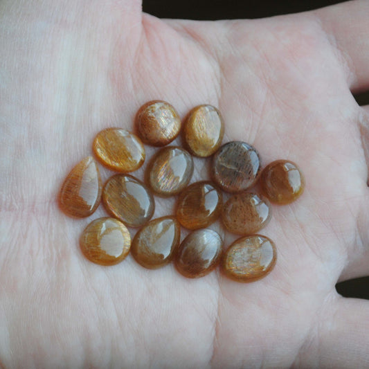 Golden sheen moonstone cabochons on palm of hand