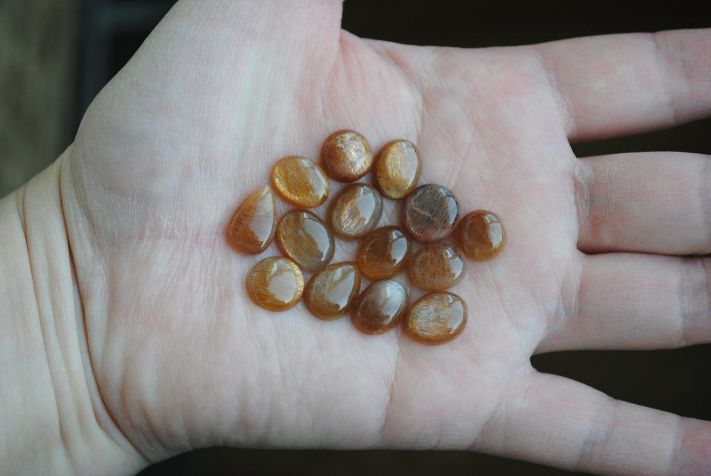 Golden sheen moonstone cabochons on palm of hand