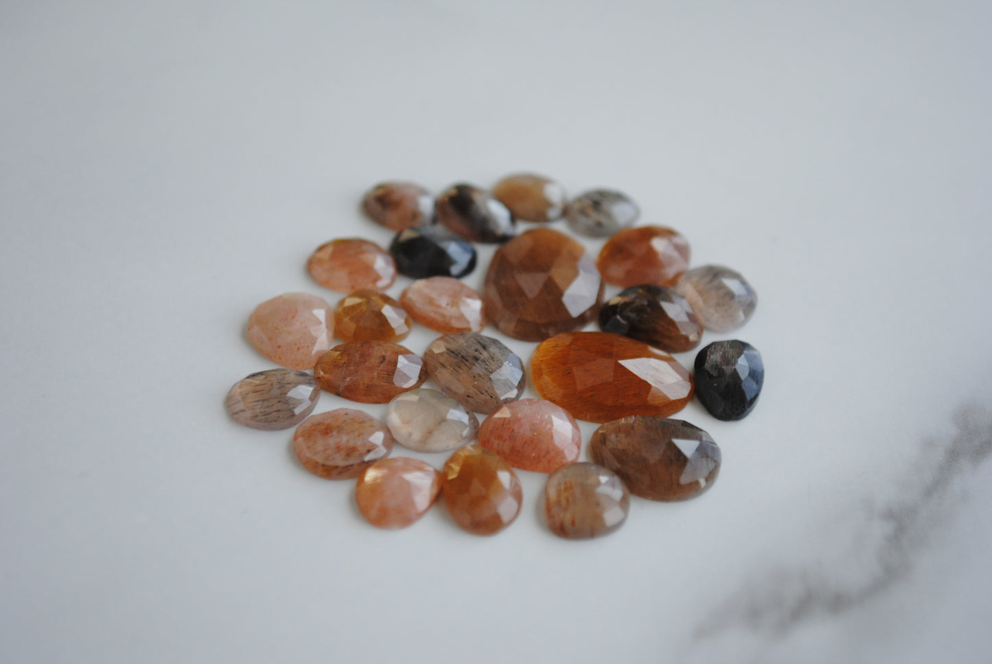 Golden sheen moonstone rose cut cabochons on light background