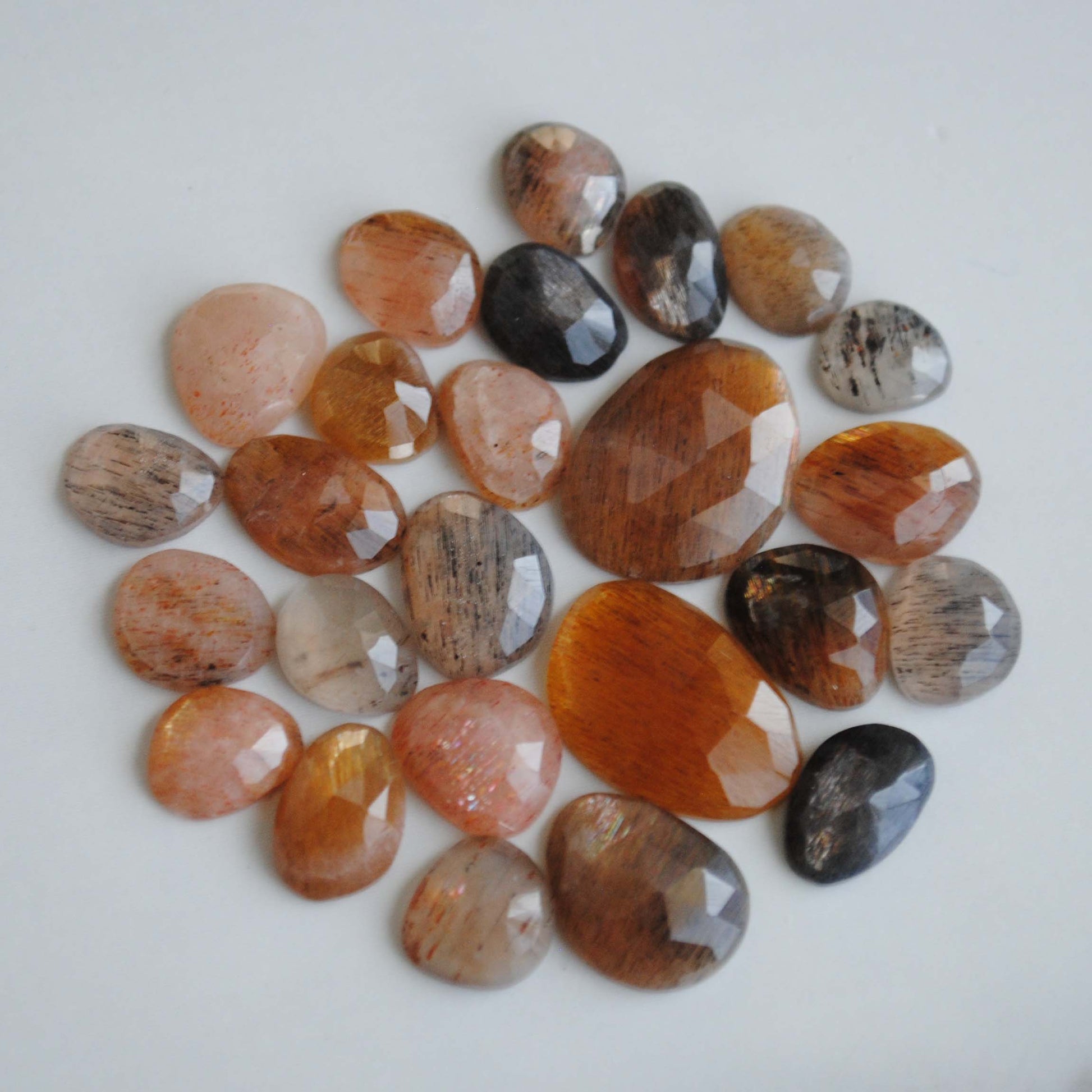 Golden sheen moonstone rose cut cabochons on light background