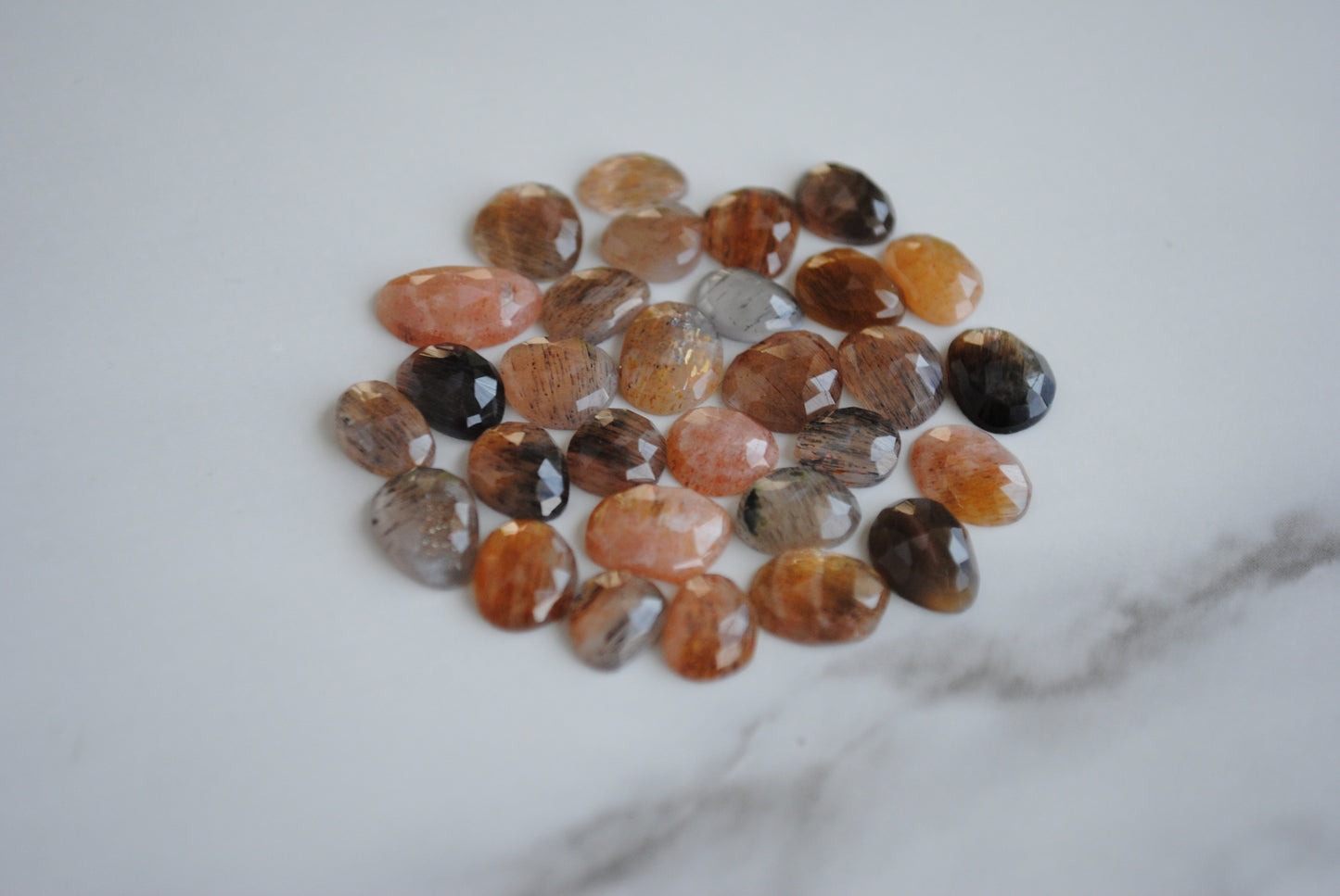 Golden sheen moonstone rose cut cabochons on light background