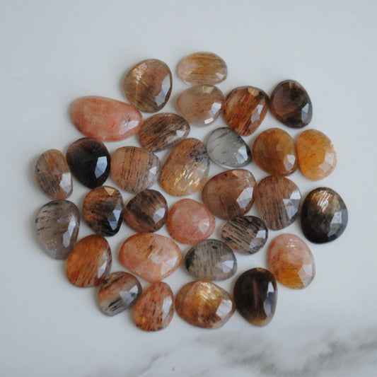 Golden sheen moonstone rose cut cabochons on light background