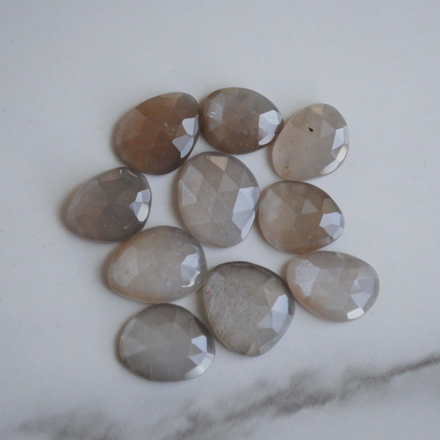 Grey moonstone rose cut cabochons on light background