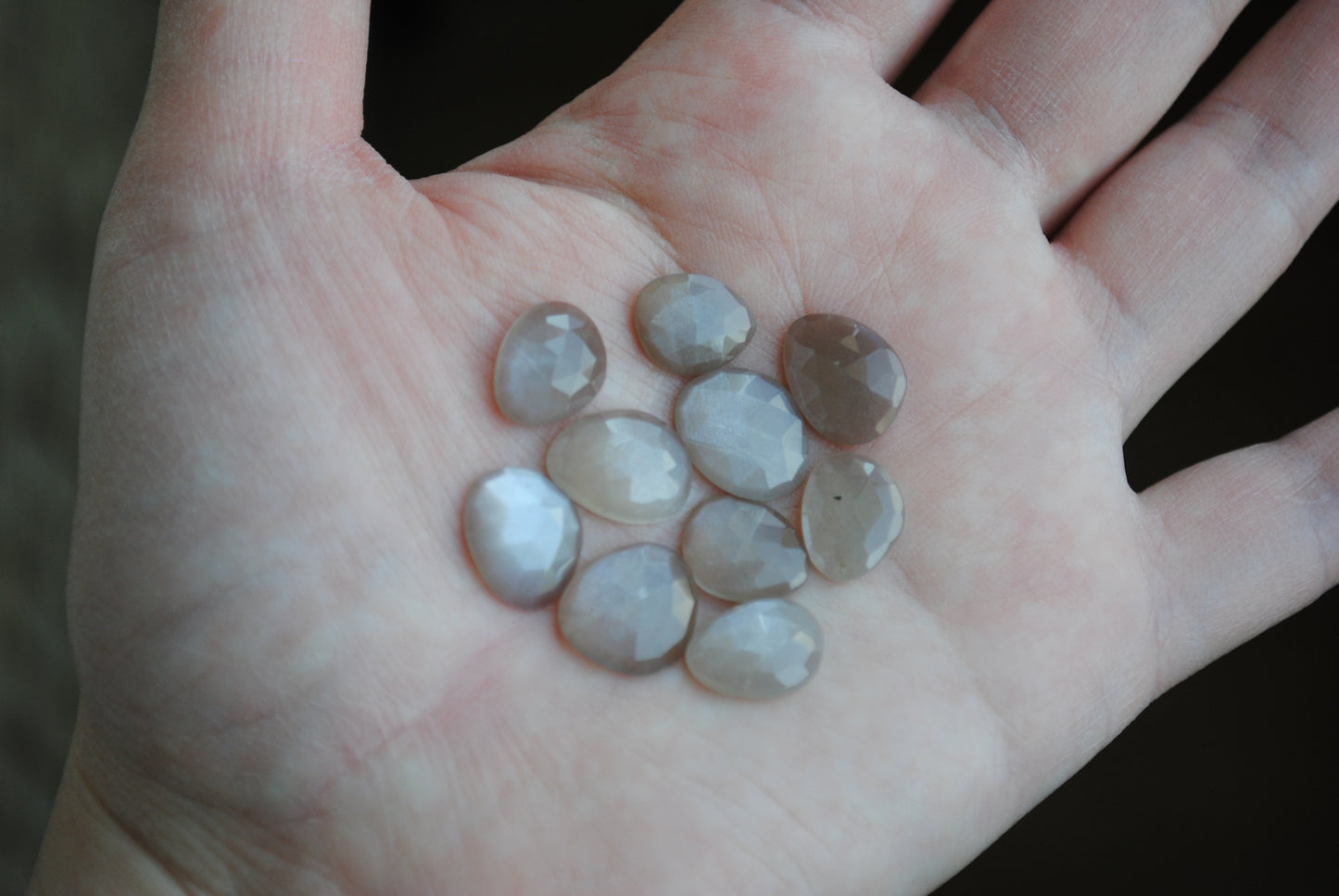 Grey moonstone rose cut cabochons on palm of hand