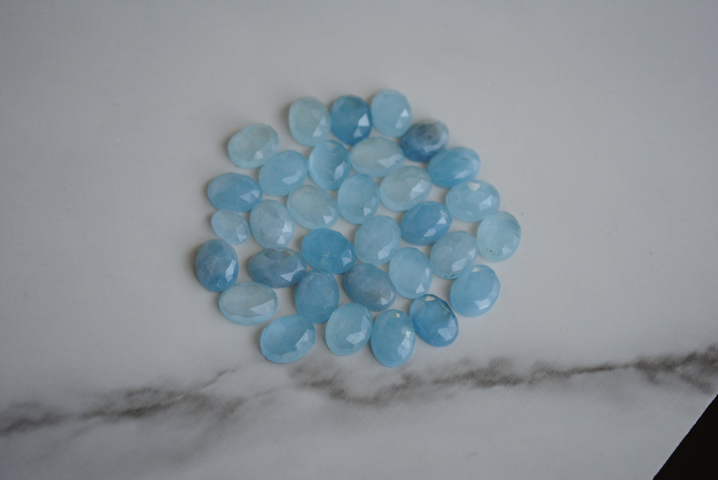 Aquamarine rose cut cabochons on light background