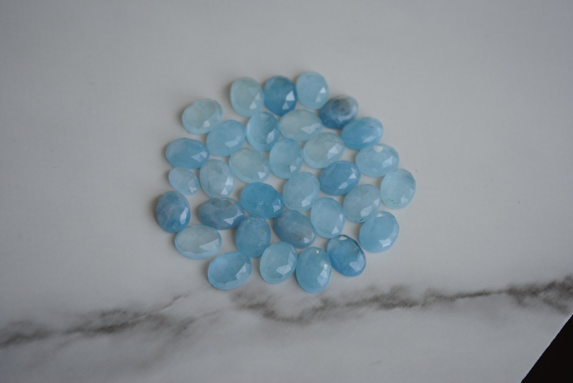 Aquamarine rose cut cabochons on light background