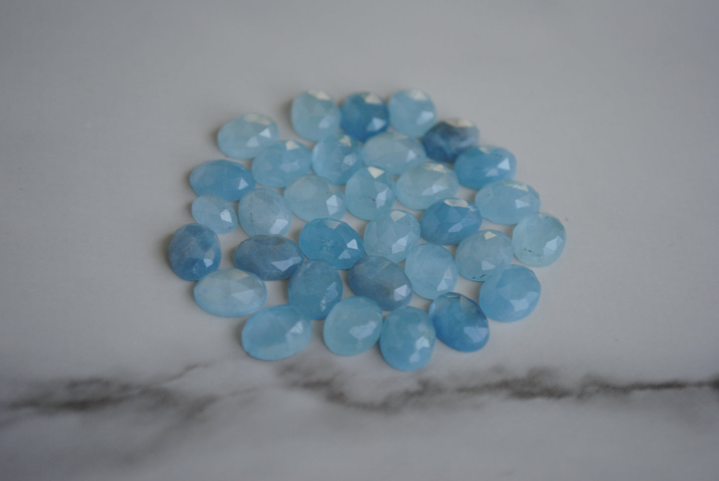 Aquamarine rose cut cabochons on light background