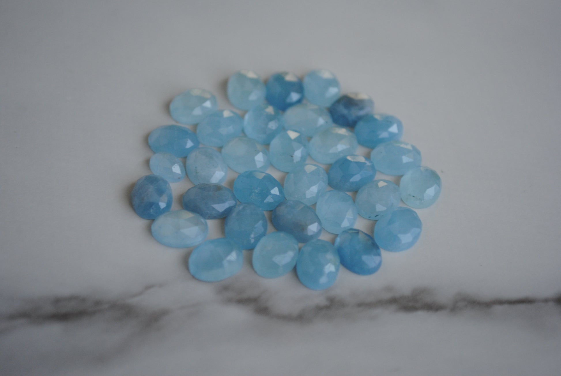Aquamarine rose cut cabochons on light background