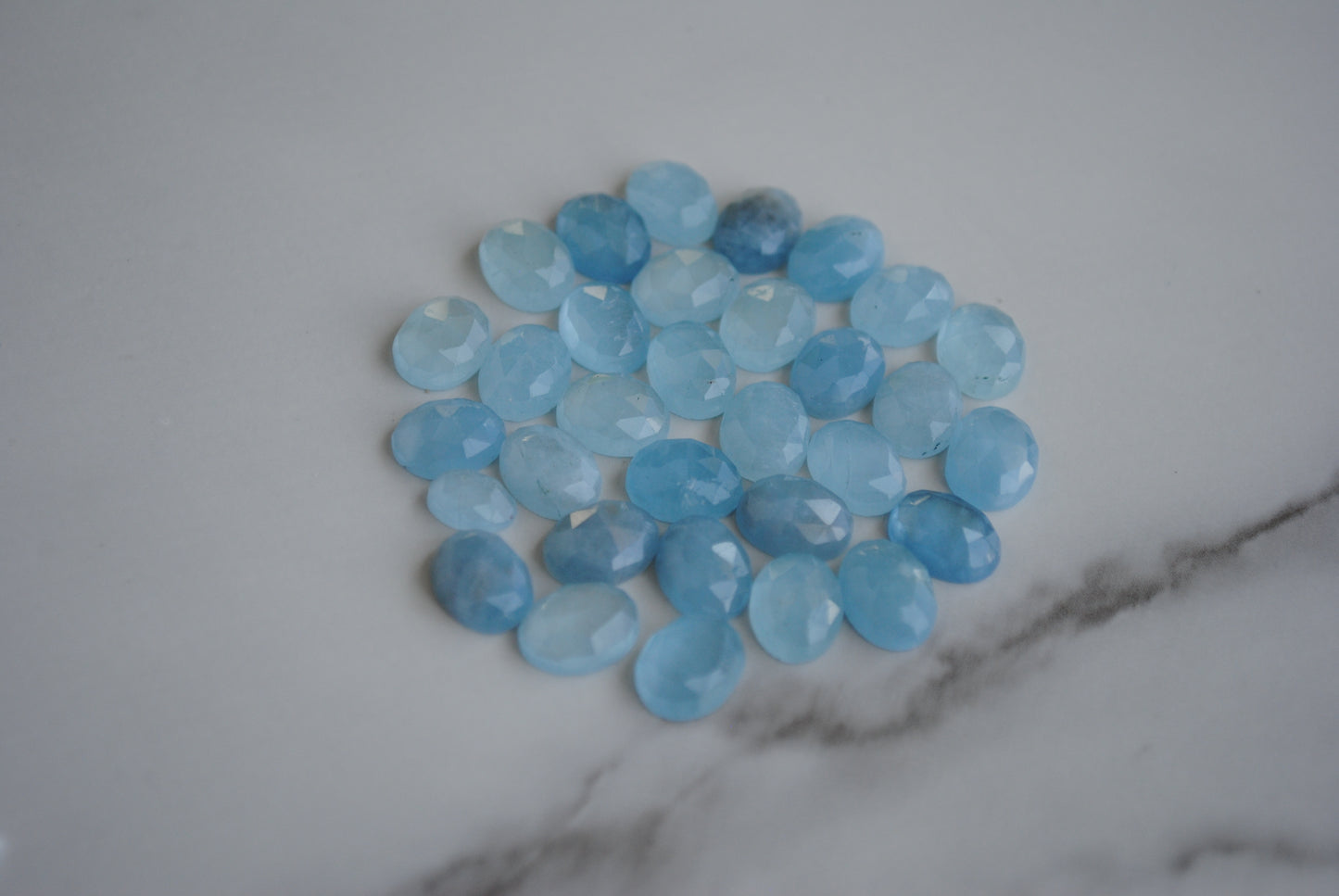 Aquamarine rose cut cabochons on light background