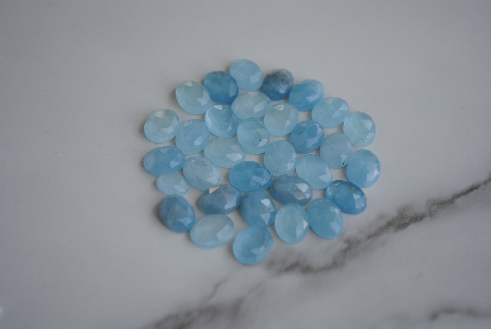 Aquamarine rose cut cabochons on light background