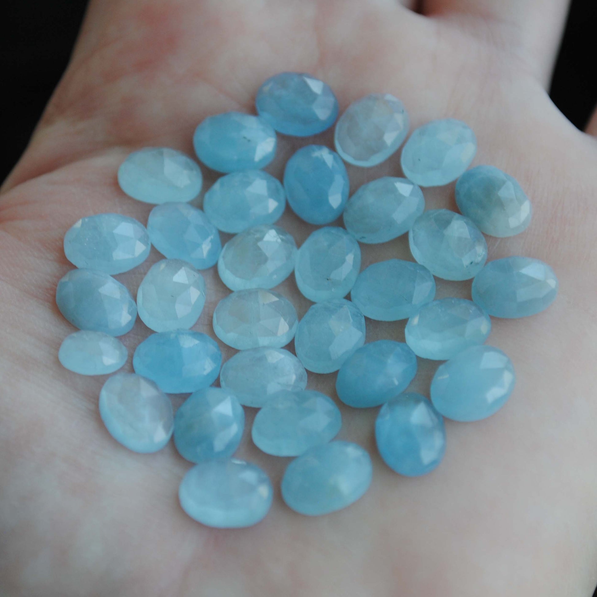 Aquamarine rose cut cabochons on palm of hand
