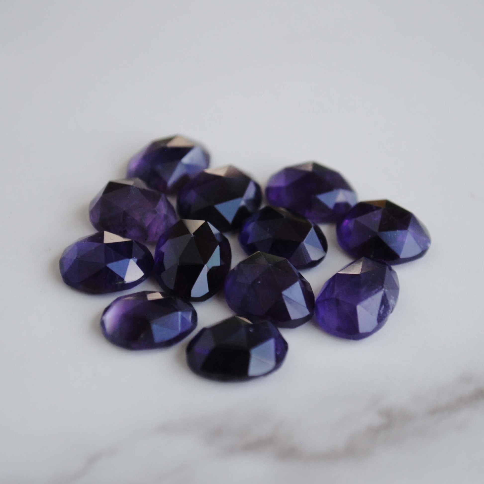 Amethyst rose cut cabochons on light background