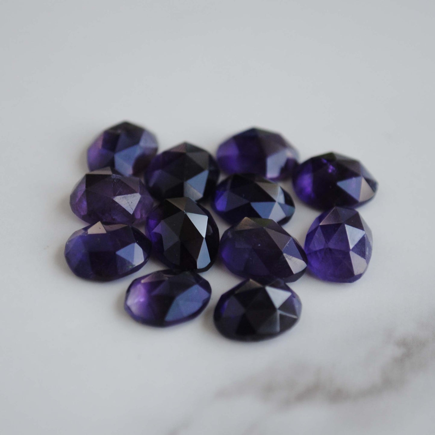 Amethyst rose cut cabochons on light background