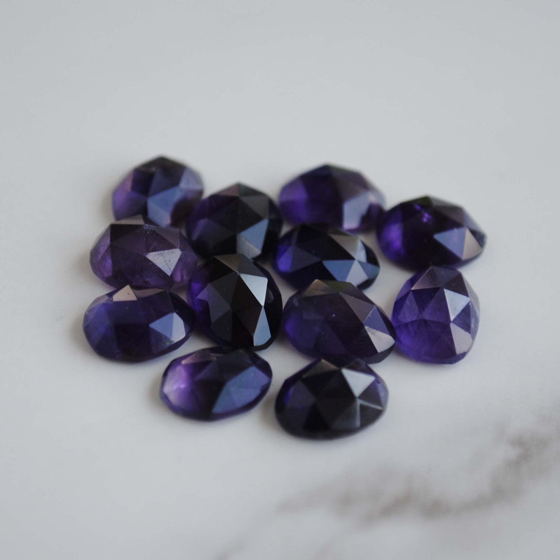 Amethyst rose cut cabochons on light background