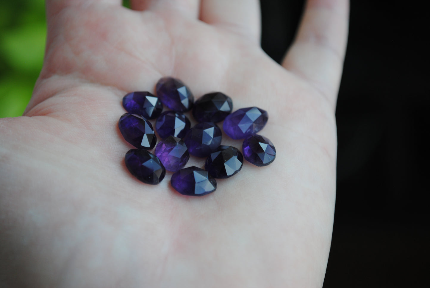Amethyst rose cut cabochons on palm of hand