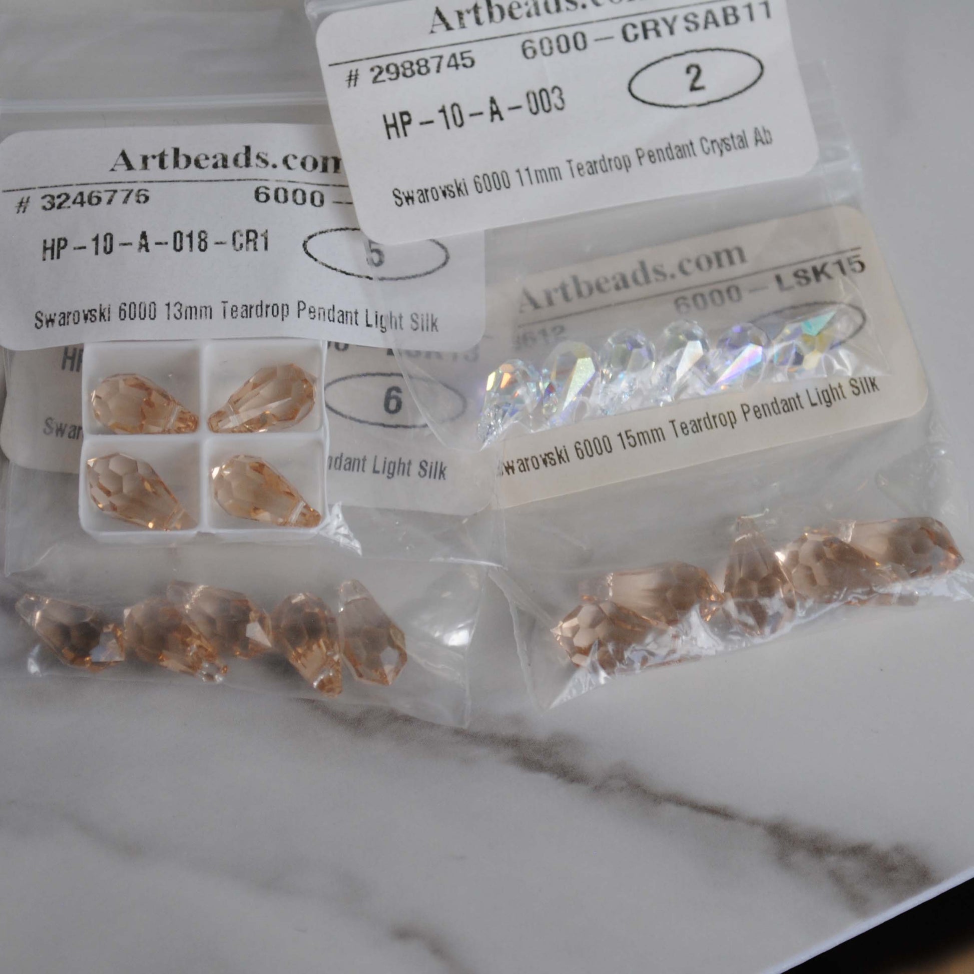 Swarovski teardrop in bags on light background