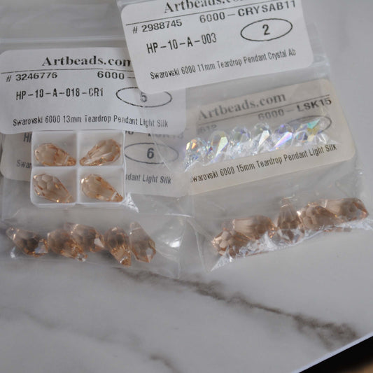 Swarovski teardrop in bags on light background